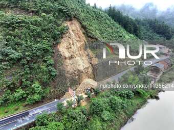 Workers are driving machinery and equipment to clear landslide soil at the site of a landslide in Datong Township on G242 National Highway i...