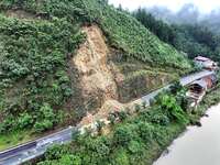 Workers are driving machinery and equipment to clear landslide soil at the site of a landslide in Datong Township on G242 National Highway i...