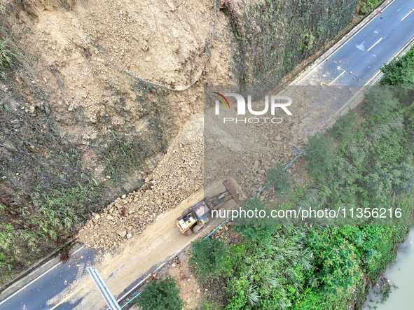 Workers are driving machinery and equipment to clear landslide soil at the site of a landslide in Datong Township on G242 National Highway i...