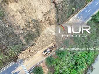 Workers are driving machinery and equipment to clear landslide soil at the site of a landslide in Datong Township on G242 National Highway i...