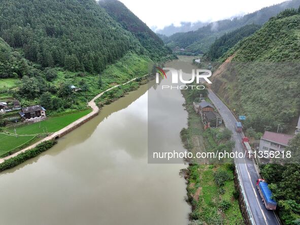 Workers are driving machinery and equipment to clear landslide soil at the site of a landslide in Datong Township on G242 National Highway i...