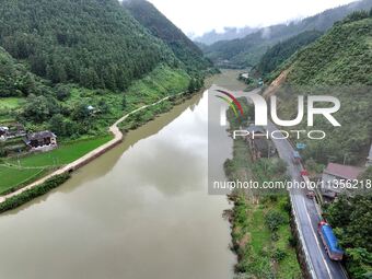 Workers are driving machinery and equipment to clear landslide soil at the site of a landslide in Datong Township on G242 National Highway i...