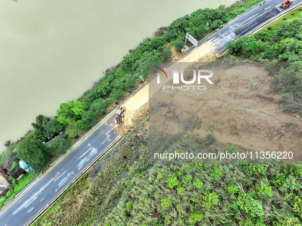 Workers are driving machinery and equipment to clear landslide soil at the site of a landslide in Datong Township on G242 National Highway i...