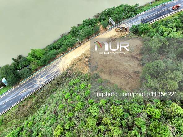 Workers are driving machinery and equipment to clear landslide soil at the site of a landslide in Datong Township on G242 National Highway i...