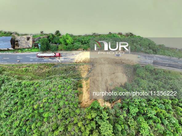 Workers are driving machinery and equipment to clear landslide soil at the site of a landslide in Datong Township on G242 National Highway i...