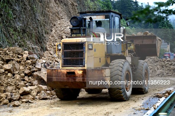 Workers are driving machinery and equipment to clear landslide soil at the site of a landslide in Datong Township on G242 National Highway i...