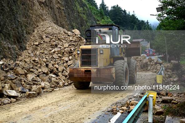 Workers are driving machinery and equipment to clear landslide soil at the site of a landslide in Datong Township on G242 National Highway i...