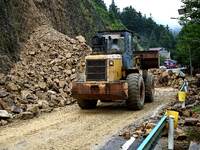 Workers are driving machinery and equipment to clear landslide soil at the site of a landslide in Datong Township on G242 National Highway i...