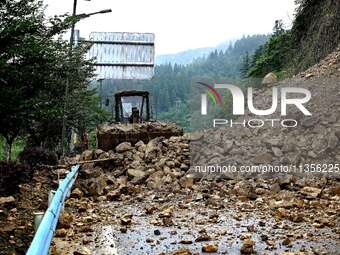 Workers are driving machinery and equipment to clear landslide soil at the site of a landslide in Datong Township on G242 National Highway i...