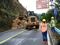 Workers are driving machinery and equipment to clear landslide soil at the site of a landslide in Datong Township on G242 National Highway i...