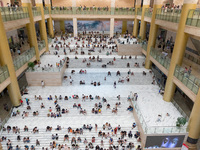 People are sitting on the steps of the hall of Shandong Museum to cool off in Jinan, China, on June 23, 2024. (