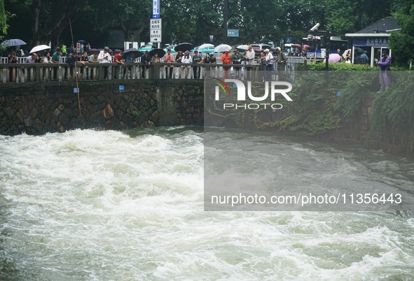 Tourists are watching the Shengtang Gate discharge water from the lake of West Lake in Hangzhou, China, on June 24, 2024. On the same day, t...