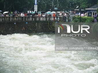 Tourists are watching the Shengtang Gate discharge water from the lake of West Lake in Hangzhou, China, on June 24, 2024. On the same day, t...