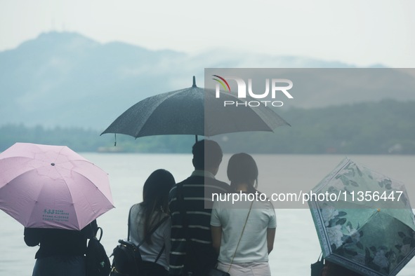 Tourists are braving the rain on the West Lake in Hangzhou, China, on June 24, 2024. On the same day, the National Meteorological Center is...