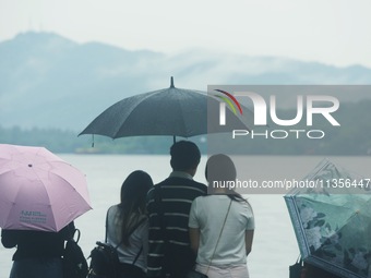 Tourists are braving the rain on the West Lake in Hangzhou, China, on June 24, 2024. On the same day, the National Meteorological Center is...