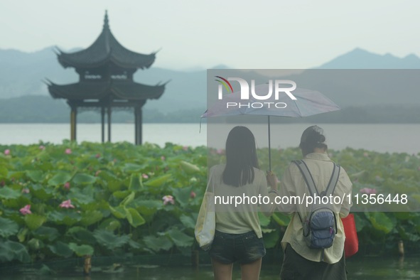 Tourists are braving the rain on the West Lake in Hangzhou, China, on June 24, 2024. On the same day, the National Meteorological Center is...