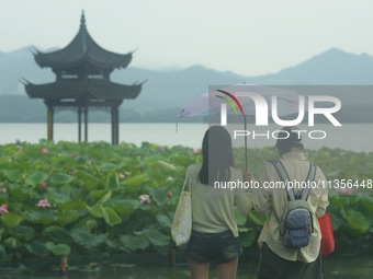 Tourists are braving the rain on the West Lake in Hangzhou, China, on June 24, 2024. On the same day, the National Meteorological Center is...