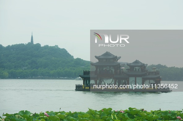 Tourists are braving the rain on the West Lake in Hangzhou, China, on June 24, 2024. On the same day, the National Meteorological Center is...