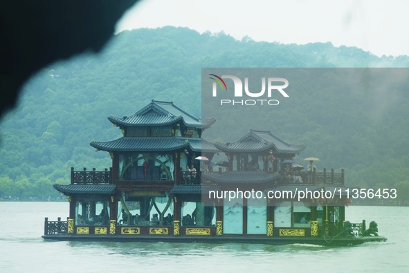 Tourists are braving the rain on the West Lake in Hangzhou, China, on June 24, 2024. On the same day, the National Meteorological Center is...