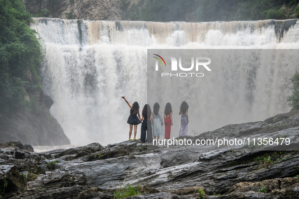 Tourists are enjoying cooling off at the Diaolan Waterfall in Xiangshui township of Bijie city, in Bijie, China, on June 23, 2024. 