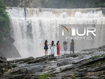 Tourists are enjoying cooling off at the Diaolan Waterfall in Xiangshui township of Bijie city, in Bijie, China, on June 23, 2024. (