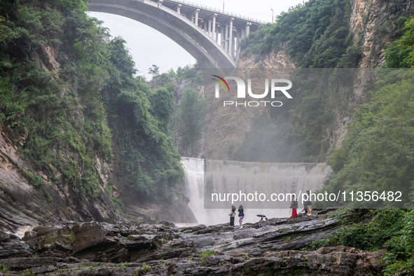 Tourists are enjoying cooling off at the Diaolan Waterfall in Xiangshui township of Bijie city, in Bijie, China, on June 23, 2024. 