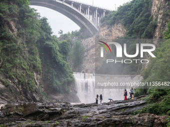 Tourists are enjoying cooling off at the Diaolan Waterfall in Xiangshui township of Bijie city, in Bijie, China, on June 23, 2024. (