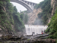 Tourists are enjoying cooling off at the Diaolan Waterfall in Xiangshui township of Bijie city, in Bijie, China, on June 23, 2024. (