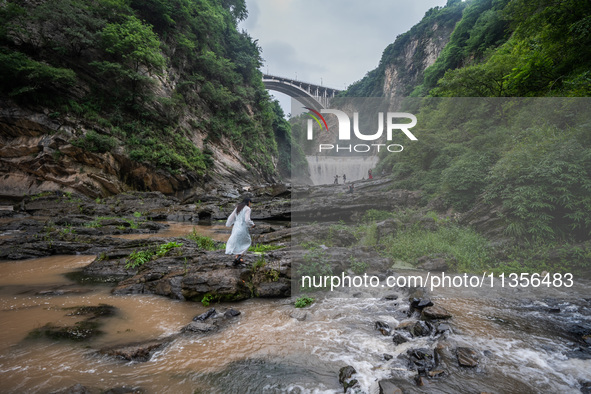 Tourists are enjoying cooling off at the Diaolan Waterfall in Xiangshui township of Bijie city, in Bijie, China, on June 23, 2024. 