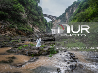 Tourists are enjoying cooling off at the Diaolan Waterfall in Xiangshui township of Bijie city, in Bijie, China, on June 23, 2024. (