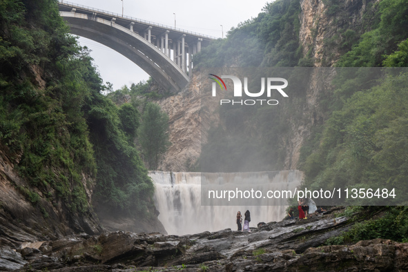 Tourists are enjoying cooling off at the Diaolan Waterfall in Xiangshui township of Bijie city, in Bijie, China, on June 23, 2024. 