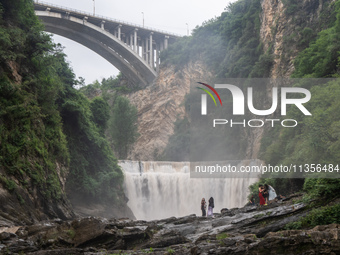 Tourists are enjoying cooling off at the Diaolan Waterfall in Xiangshui township of Bijie city, in Bijie, China, on June 23, 2024. (