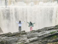 Tourists are enjoying cooling off at the Diaolan Waterfall in Xiangshui township of Bijie city, in Bijie, China, on June 23, 2024. (