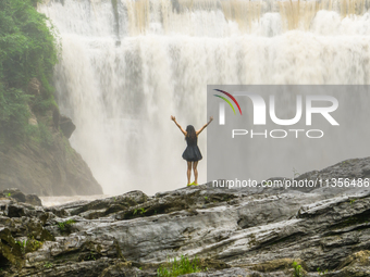 Tourists are enjoying cooling off at the Diaolan Waterfall in Xiangshui township of Bijie city, in Bijie, China, on June 23, 2024. (