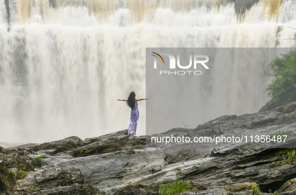 Tourists are enjoying cooling off at the Diaolan Waterfall in Xiangshui township of Bijie city, in Bijie, China, on June 23, 2024. 