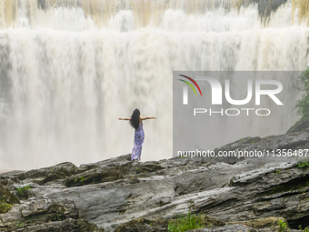 Tourists are enjoying cooling off at the Diaolan Waterfall in Xiangshui township of Bijie city, in Bijie, China, on June 23, 2024. (