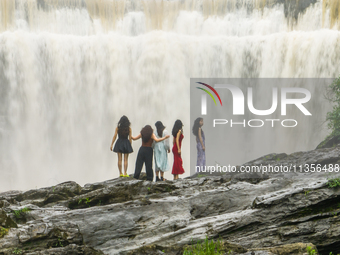 Tourists are enjoying cooling off at the Diaolan Waterfall in Xiangshui township of Bijie city, in Bijie, China, on June 23, 2024. (