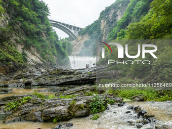 Tourists are enjoying cooling off at the Diaolan Waterfall in Xiangshui township of Bijie city, in Bijie, China, on June 23, 2024. (