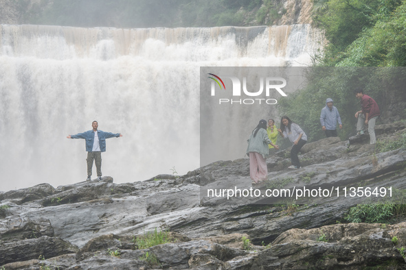 Tourists are enjoying cooling off at the Diaolan Waterfall in Xiangshui township of Bijie city, in Bijie, China, on June 23, 2024. 