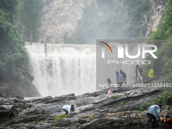 Tourists are enjoying cooling off at the Diaolan Waterfall in Xiangshui township of Bijie city, in Bijie, China, on June 23, 2024. (