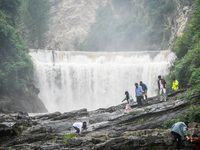 Tourists are enjoying cooling off at the Diaolan Waterfall in Xiangshui township of Bijie city, in Bijie, China, on June 23, 2024. (