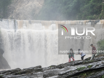 Tourists are enjoying cooling off at the Diaolan Waterfall in Xiangshui township of Bijie city, in Bijie, China, on June 23, 2024. (