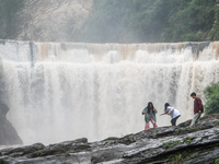 Tourists are enjoying cooling off at the Diaolan Waterfall in Xiangshui township of Bijie city, in Bijie, China, on June 23, 2024. (