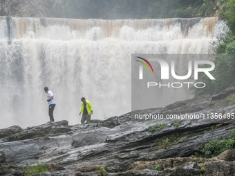 Tourists are enjoying cooling off at the Diaolan Waterfall in Xiangshui township of Bijie city, in Bijie, China, on June 23, 2024. (