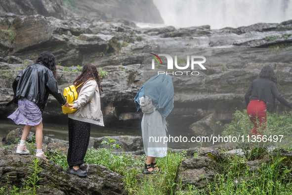 Tourists are enjoying cooling off at the Diaolan Waterfall in Xiangshui township of Bijie city, in Bijie, China, on June 23, 2024. 