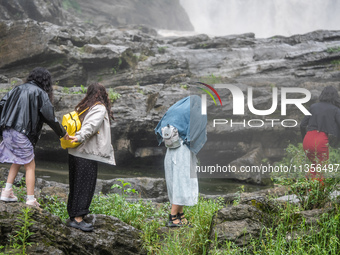 Tourists are enjoying cooling off at the Diaolan Waterfall in Xiangshui township of Bijie city, in Bijie, China, on June 23, 2024. (