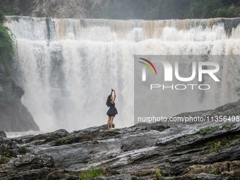 Tourists are enjoying cooling off at the Diaolan Waterfall in Xiangshui township of Bijie city, in Bijie, China, on June 23, 2024. (