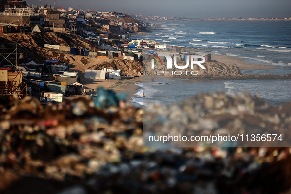 A general view is showing tents housing internally displaced Palestinians crowding the beach and the Mediterranean shoreline in Deir el-Bala...