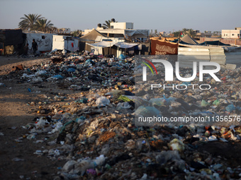 A view is showing piles of garbage next to the tents housing internally displaced Palestinians crowding the beach and the Mediterranean shor...