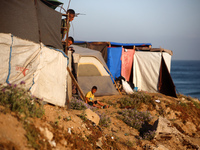 Displaced Palestinian children are looking outside their tent at the beach in Deir el-Balah, central Gaza Strip, on June 24, 2024, amid the...